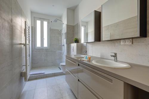 une salle de bain avec un lavabo, des toilettes et une douche dans l'établissement Méricourt Suite, Place de la République, à Paris