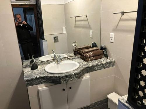 a man taking a picture of a bathroom sink at Casa Leon Cabo de Palos in Cabo de Palos