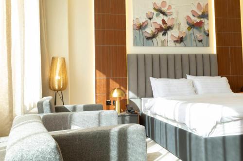 a bedroom with a bed and a couch and a chair at Park Avenues Hotel in Kuwait