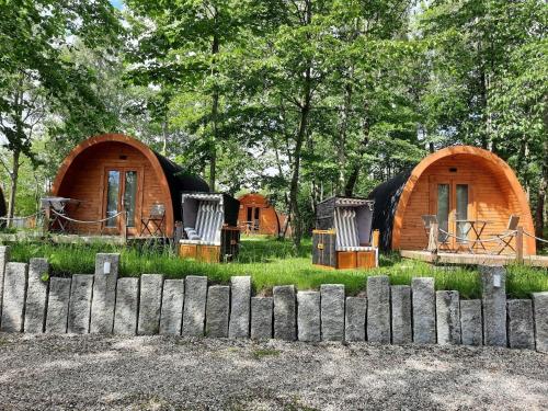 a group of huts in a field with a fence at 26 Premium Camping Pod "Föhr" in Silberstedt