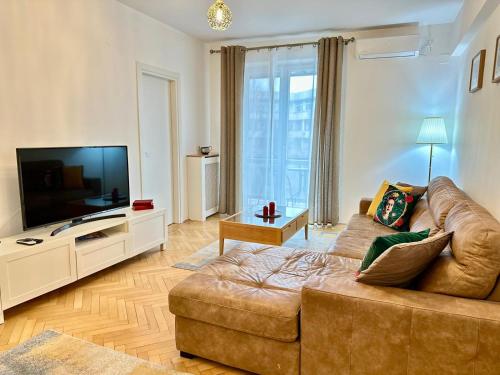a living room with a couch and a flat screen tv at 2Rooms Apartment Universitate-Old Town in Bucharest