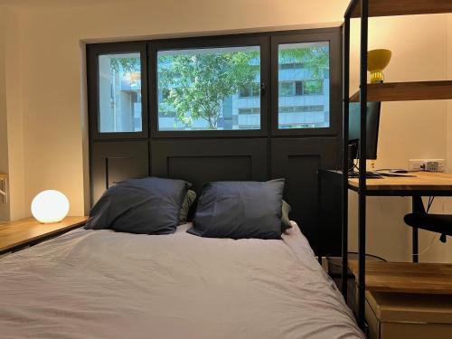 - une chambre avec un lit avec deux oreillers et deux fenêtres dans l'établissement Etage Meynadier, à Paris