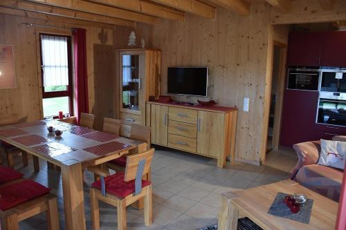 a kitchen and dining room with a table and a television at Ferienhaus Nr 15C, Feriendorf Hagbügerl, Bayr Wald in Waldmünchen