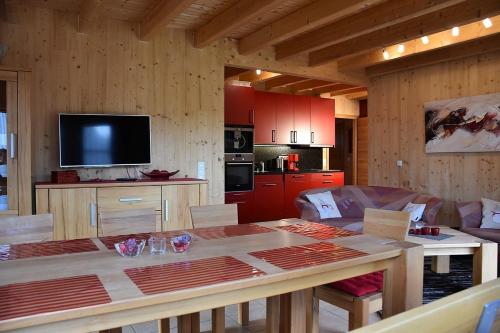 a living room with a table and a kitchen at Ferienhaus Nr 15C, Feriendorf Hagbügerl, Bayr Wald in Waldmünchen