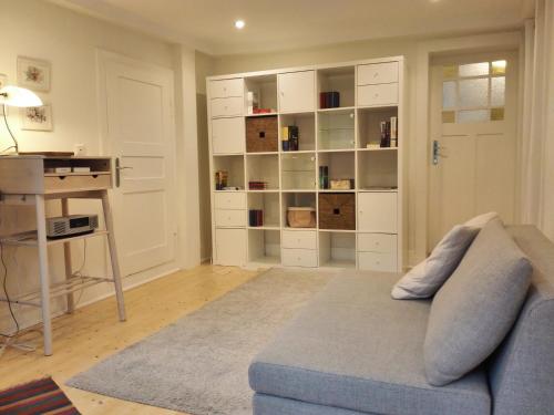 a living room with a blue couch and a desk at Ferienhaus Landhaus Am Hirtzborn in Marbach