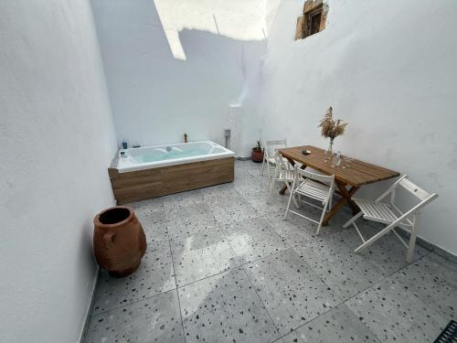 a bathroom with a tub and a table with chairs at Philoxenia traditional house private jacuzzi in Palaiólimnos