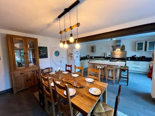 une salle à manger avec une table en bois et une cuisine dans l'établissement A 9 min du 