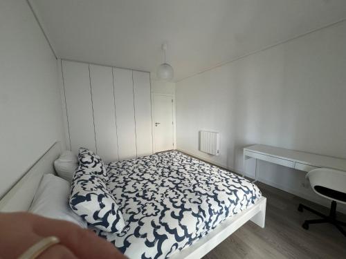 a small bedroom with a bed and a desk at Apartamento da Vagueira in Praia da Vagueira