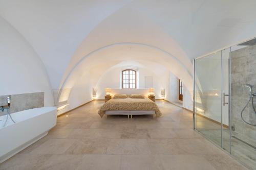 Großes weißes Zimmer mit einem Bett und einer Dusche. in der Unterkunft Exceptionnel - Couvent entièrement rénové - classé Patrimoine - Piscine, au calme et à 100 m du coeur de l'Isle in LʼIsle-sur-la-Sorgue