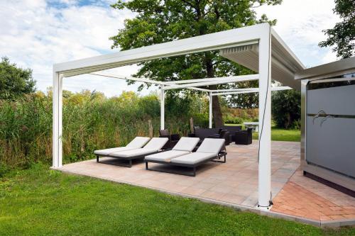 a pavilion with white chairs and a large screen at A 5 Ferienhaus Triton in Gramkow