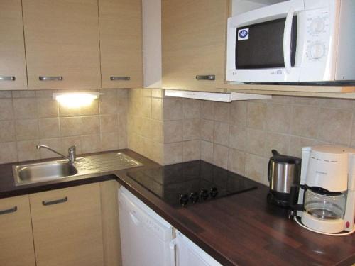 une cuisine avec un évier et un micro-ondes dans l'établissement Studio Confort 4 Pers. avec Balcon, Parking et Wi-Fi - Brides-les-Bains - FR-1-512-89, à Brides-les-Bains