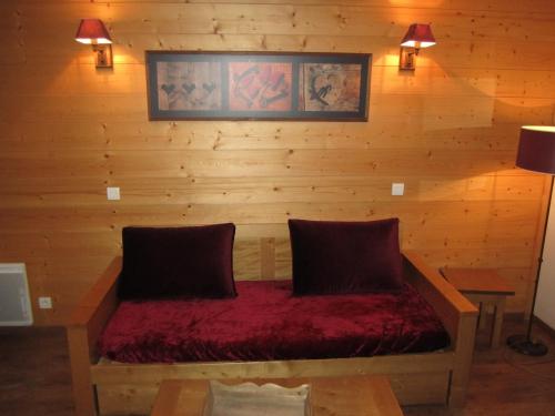 Cette chambre est dotée d'un mur en bois avec un banc et 2 oreillers. dans l'établissement Studio Confort 4 Pers. avec Balcon, Parking et Wi-Fi - Brides-les-Bains - FR-1-512-89, à Brides-les-Bains