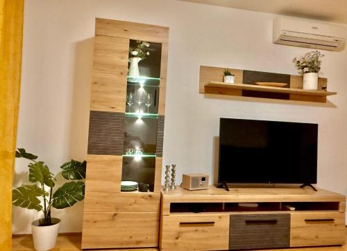 a living room with a tv and a wooden entertainment center at Sunflower Apartment Moravske Toplice in Moravske Toplice
