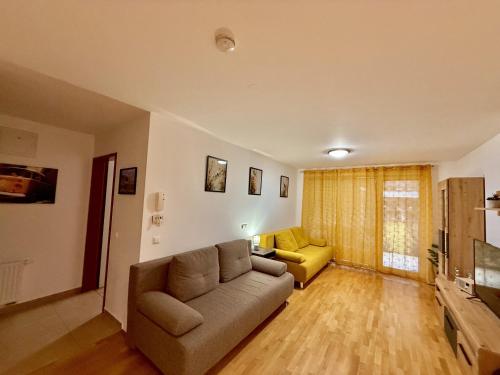 a living room with a couch and a yellow chair at Sunflower Apartment Moravske Toplice in Moravske Toplice