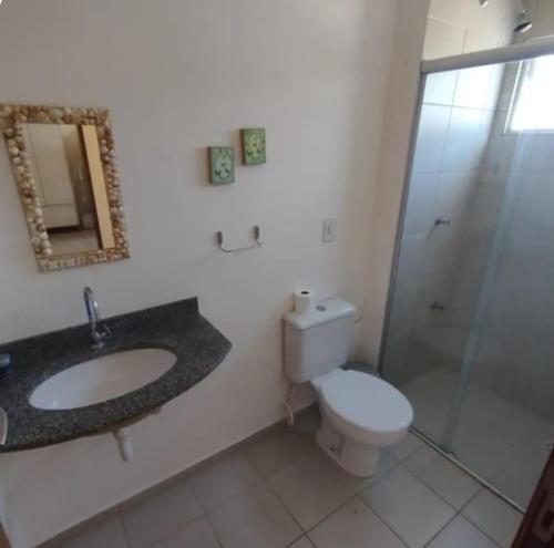 a bathroom with a toilet and a sink and a shower at Paraíso de Maracajaú IV in Maxaranguape