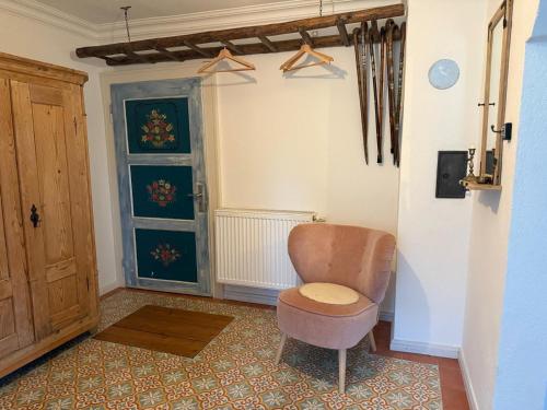 a living room with a chair and a door at Ferienwohnung Hörlkofen in Wörth