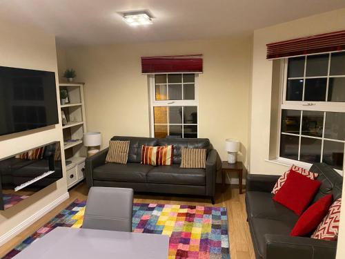 a living room with a couch and a tv at 4 bed Duplex Apartment, Belfast in Belfast