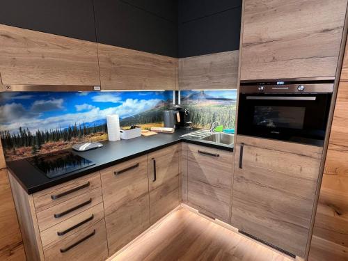 a kitchen with a large painting on the wall at Luxusní apartmán Perla in Říčky