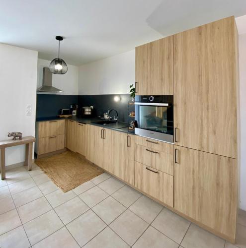 une cuisine avec des armoires en bois et un comptoir dans l'établissement L'Artisane, duplex lumineux en bord de Vilaine, à Rennes