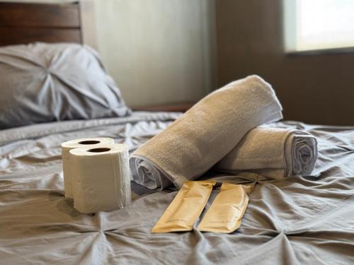 a bed with two rolls of towels and a pair of napkins at 1BR Luxury Condo, Centrio Tower, Ayala Malls in Cagayan de Oro