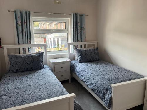 a bedroom with two beds and a window at Two Four Four, holiday home in Matlock in Matlock