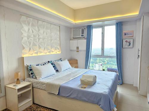 ein Schlafzimmer mit einem großen Bett mit einem großen Fenster in der Unterkunft 26th Sky View Home in Cebu City