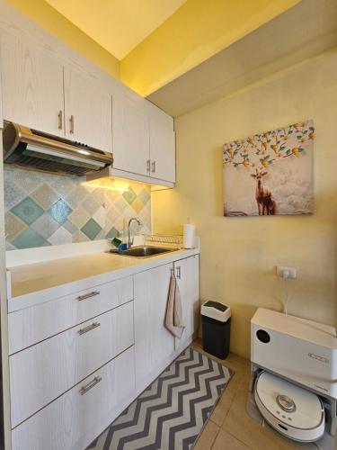 eine Küche mit weißen Schränken und einer Spüle in der Unterkunft 26th Sky View Home in Cebu City