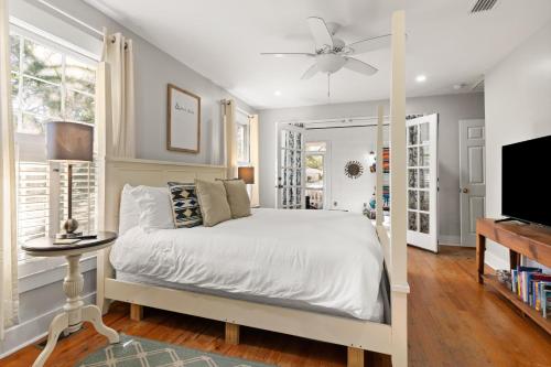 a bedroom with a white bed and a tv at Sunshine Daydreams - 4310 Seventh Street in Saint Simons Island