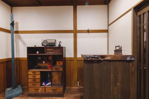 a room with a counter and a wooden cabinet at Couch Potato Hostel - Vacation STAY 88233 in Matsumoto