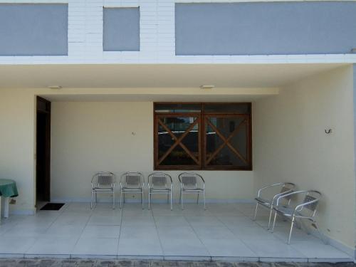 a group of chairs lined up against a wall at Casa na Barra de São Miguel - 200mt da praia in Barra de São Miguel