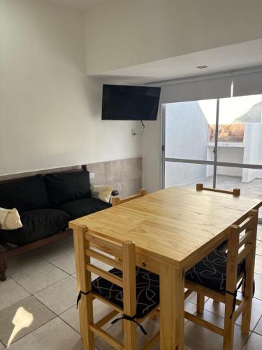a living room with a wooden table and a couch at Sabattini Apart in Villa María