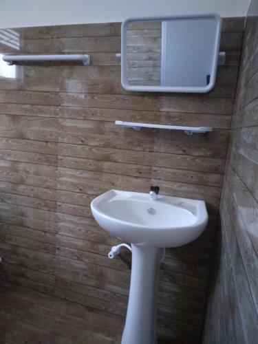 a bathroom with a white sink and a mirror at SunRay Rest - Beach View Homestay in Mirissa