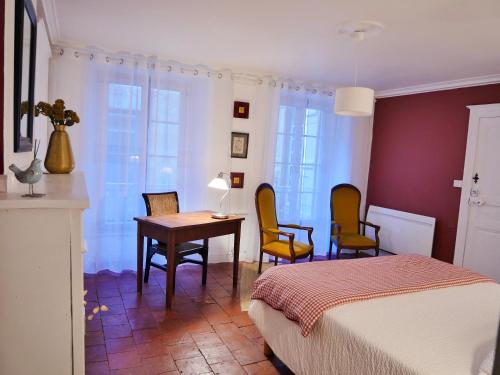 une chambre avec un lit, une table et des chaises dans l'établissement Alice & Jeanne - Chambre d'hôte, à Lectoure