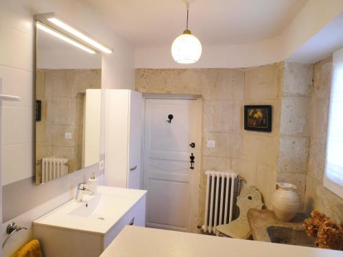 une salle de bain avec un lavabo blanc et un miroir dans l'établissement Alice & Jeanne - Chambre d'hôte, à Lectoure