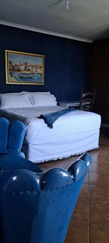 a bedroom with two beds and a blue chair at Gae la boroko in Brakpan