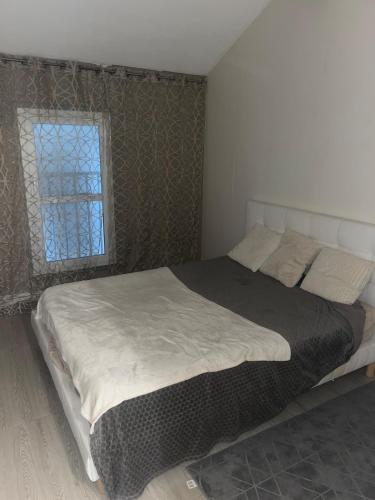 un grand lit dans une chambre avec une fenêtre dans l'établissement 3 room sauna apartment, à Saint-Jean-de-Braye