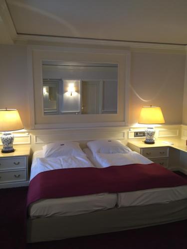 a bedroom with a large bed with two lamps at Hotel Lippischer Hof in Detmold