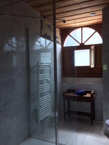La salle de bains est pourvue d'une douche en verre et d'une table. dans l'établissement Manoir de Damigny, à Saint-Martin-des-Entrées