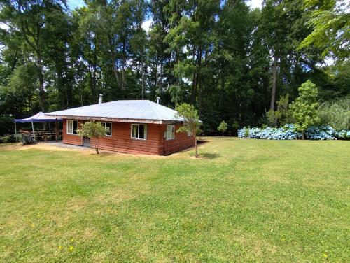 a small cabin in the middle of a yard at Cabaña Leandro Lago Panguipulli in Panguipulli