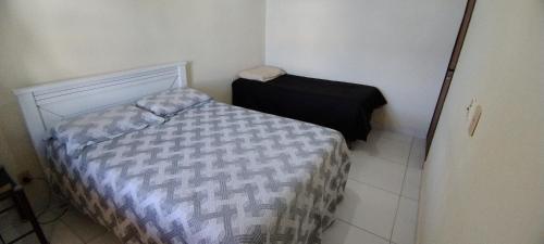 a small bedroom with a bed in a room at Casa na Barra de São Miguel - 200mt da praia in Barra de São Miguel