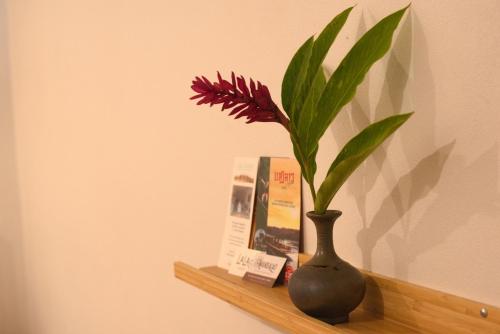 a vase sitting on a shelf with a flower in it at Nongkham in Luang Prabang