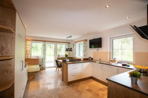 a kitchen with white cabinets and a dining room at Ferienhaus zur Kundler Klamm by FeWo-Plan WILD012 in Dorf