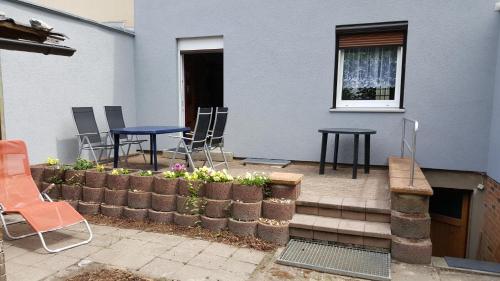 a patio with two chairs and two tables and flowers at Ferienhaus am Geiseltalsee in Braunsbedra