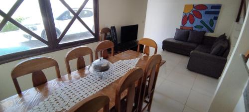 a dining table and chairs in a living room at Casa na Barra de São Miguel - 200mt da praia in Barra de São Miguel
