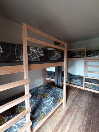 une chambre avec trois lits superposés dans une pièce dans l'établissement Gite d'étape, à Osmanville