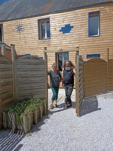 deux femmes sortant d'un bâtiment en bois dans l'établissement Gite d'étape, à Osmanville