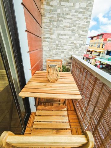 a wooden table on the balcony of a building at IXA Amakan Loft in Puerto Princesa City