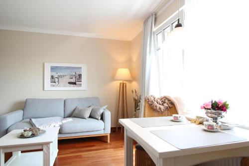 a living room with a couch and a table at Haus am Park Wohnung Nr8 in Spiekeroog