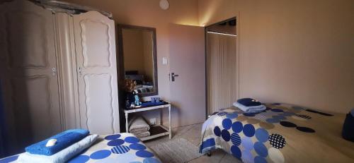 a small bedroom with a bed and a mirror at The Third Dolphin in Herolds Bay