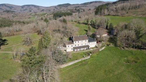 une vue aérienne d'une grande maison dans un champ dans l'établissement La petite maison dans la montagne, à La Salvetat-sur-Agout
